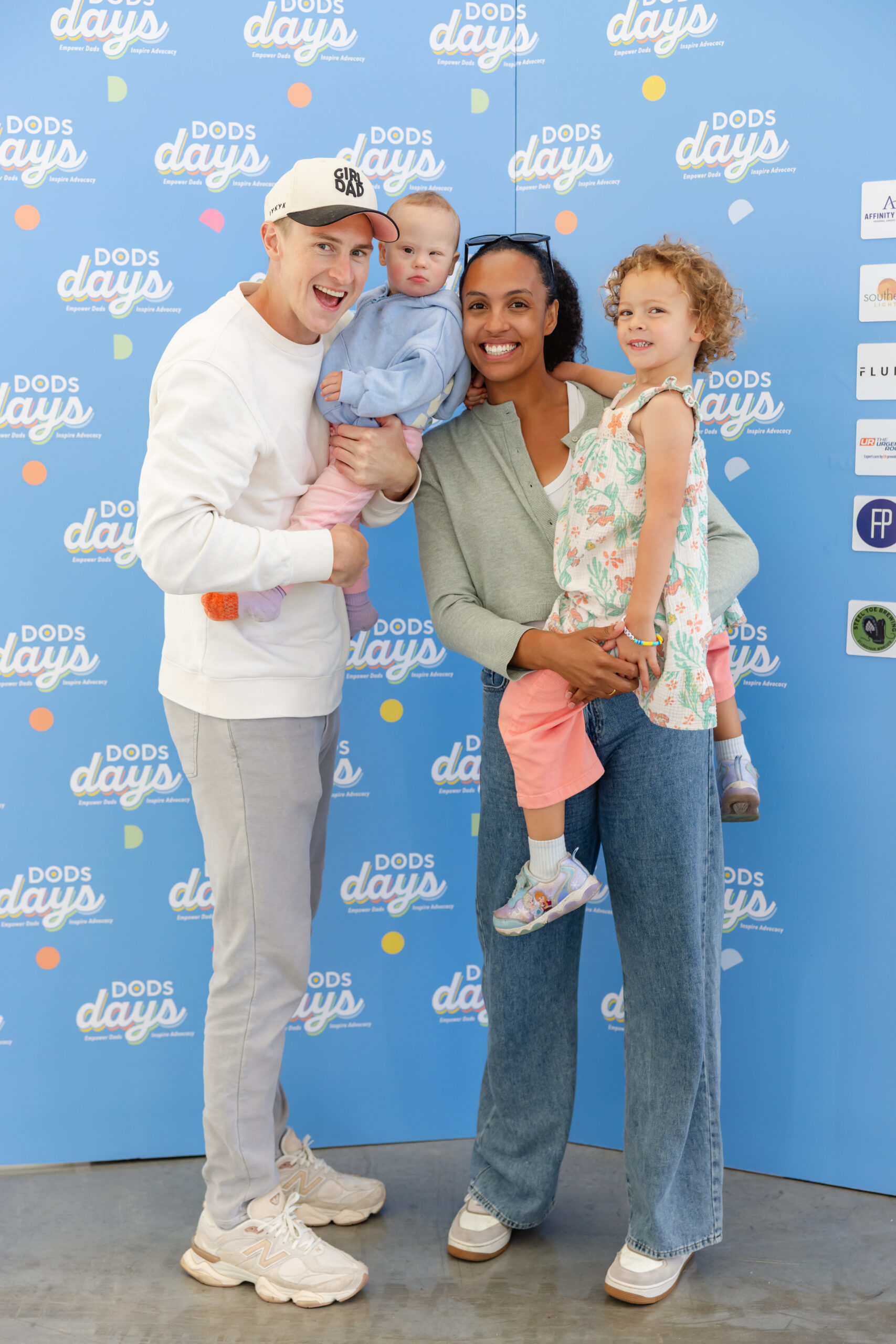 A family posing at the DODs Days photo backdrop